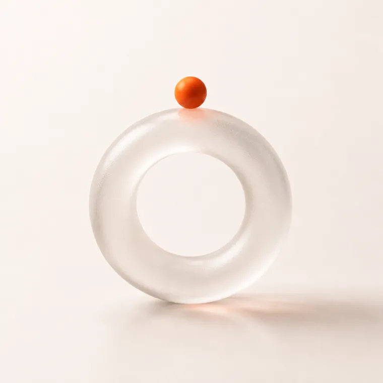 Abstract frosted-glass ring with an orange sphere representing launch and growth
