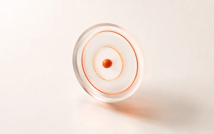 Abstract render of a glass lens and orange rings representing SEO by Holvine